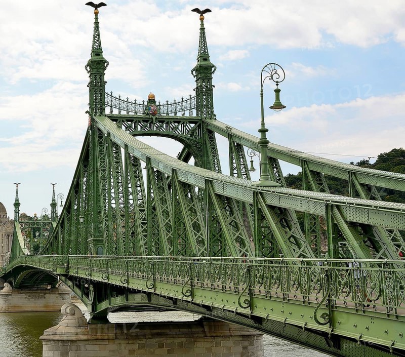 Liberty bridge, a green steel bridge, is standing over danube river in budapest, hungary, connecting buda and pest