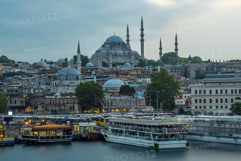 Suleymaniye mosque at dusk, with ferry boats navigating the golden horn, creates a captivating view of istanbul's historical skyline