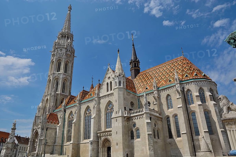 Matthias church with its colorful roof tiles and tall bell tower standing tall against a blue sky in budapest, hungary