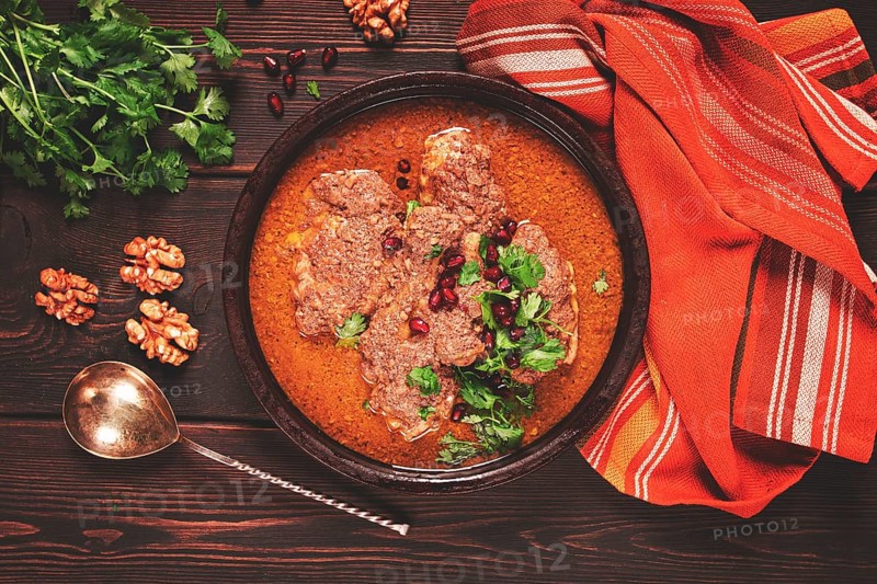 Fesenjan, an Iranian dish, stewed chicken, in walnut-pomegranate sauce, in an earthen pan, homemade, no people