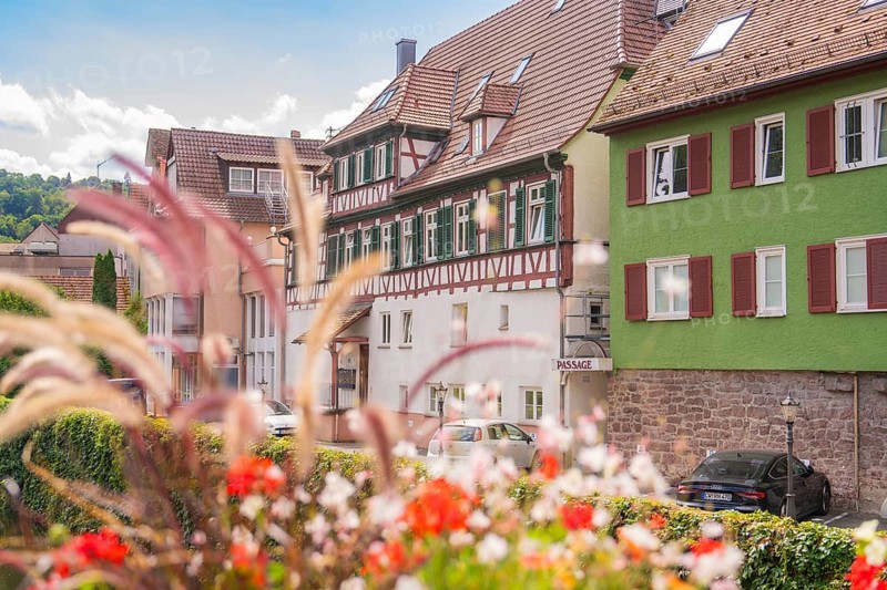 Street view with old houses and flowers offers a summery, historical impression, small town pearl Calw, Black Forest, Germany