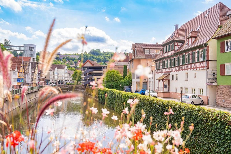 Idyllic river view with half-timbered houses and flowers in a summery atmosphere, small town pearl Calw, Black Forest, Germany