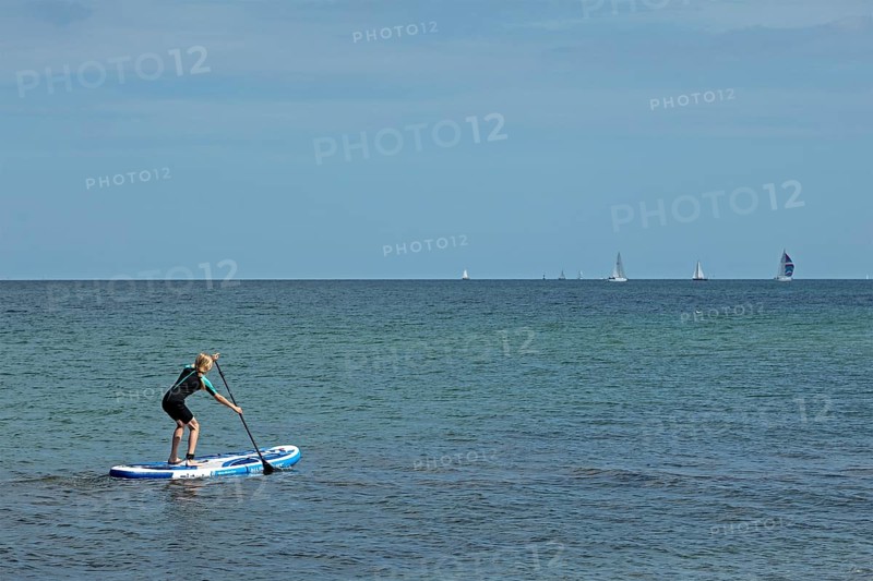 Girl stand-up paddling, Strande, Schleswig-Holstein, Germany
