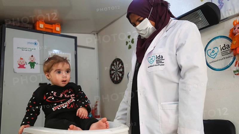 A doctor examining a refugee child for malnutrition in the camp using weight and height measurement. Aleppo, Syria October 18, 2022, Aleppo, Syria