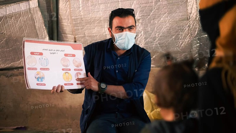A community health worker giving instructions to refugees on how to deal with the cholera outbreak that spread in Syrian refugee camps. Aleppo, Syria. October 29, 2022, Aleppo, Syria