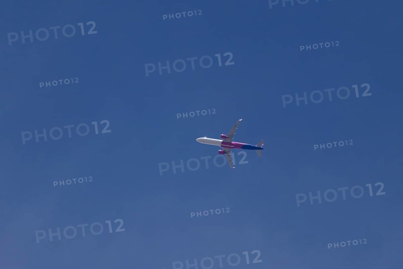 Airbus A321 jet aircraft of Wizz Air airlines in flight in a blue sky, England, United Kingdom