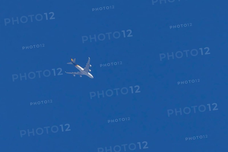 Boeing 747 jumbo jet cargo aircraft of UPS United Postal Service flying in a blue sky, England, United Kingdom