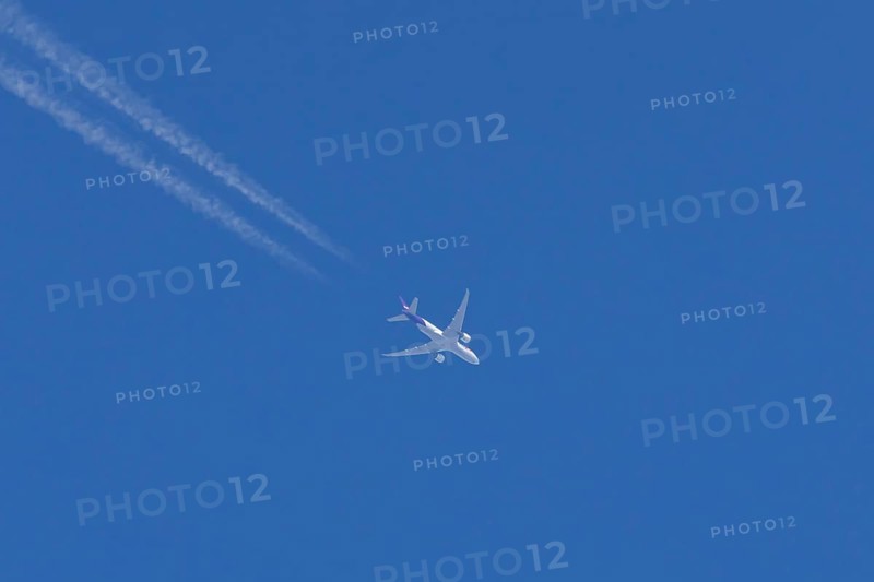 Airbus A300-600RF jet aircraft of FedEx Express airlines in flight with vapour trails or contrails behind in a blue sky, England, United Kingdom
