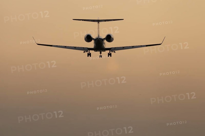 Executive business jet passenger aircraft landing at sunset, London Stansted airport, Essex, England, United Kingdom