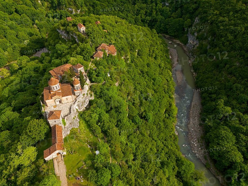 Aerial view of a monastery on a river, embedded in lush nature, aerial view, Motsameta Monastery, near Kutaisi, Zkalzitela River, Imeretia region, Georgia