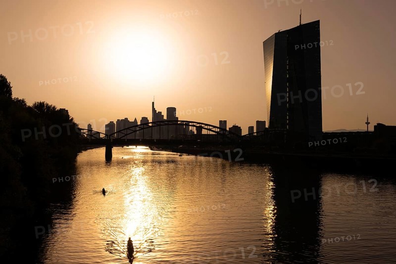 The sun is high above the European Central Bank (ECB) and the Frankfurt banking skyline, Frankfurt am Main, Hesse, Germany