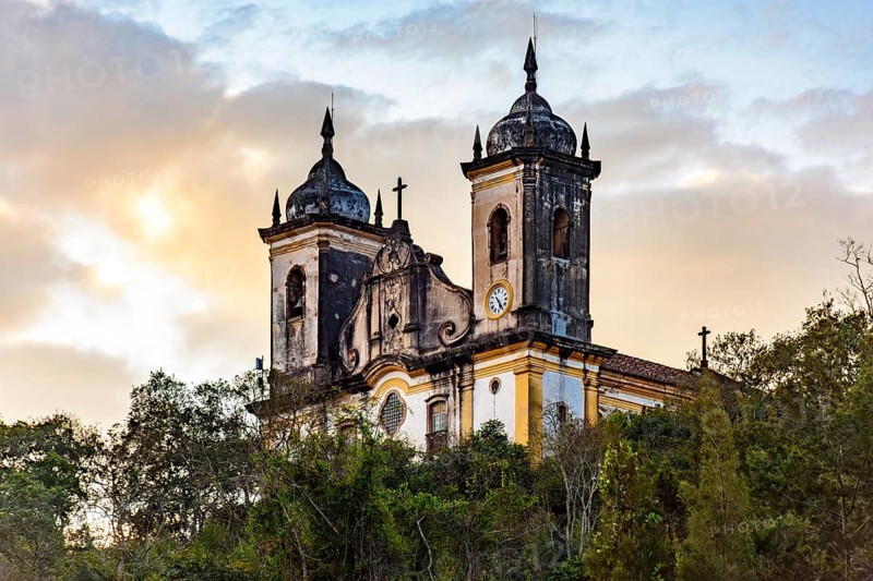 Baroque church behind the vegetation in the hills of the city of Ouro Preto