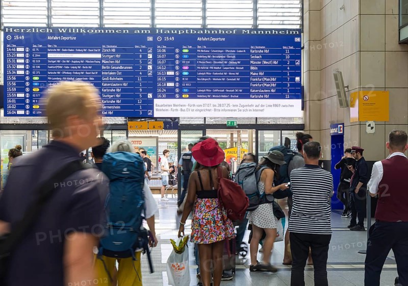 Mannheim main station, interior view with people and display board. Mannheim, Baden-Württemberg, Germany