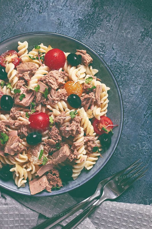 Fusilli pasta salad with canned tuna, cherry tomatoes and olives, parmesan, microgreens, homemade, no people