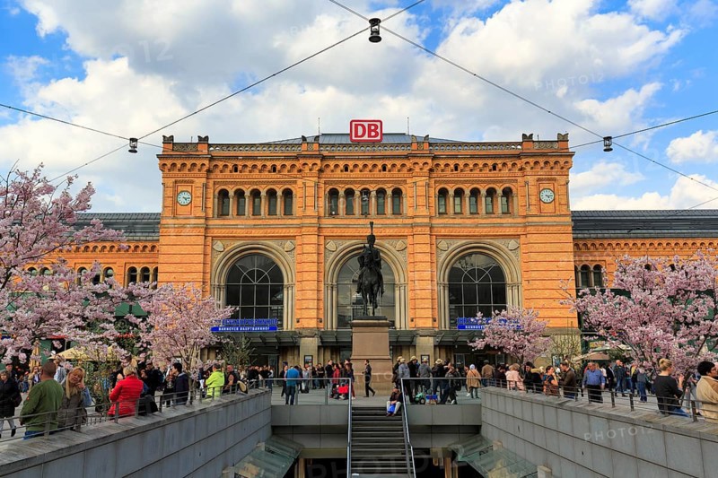 Hanover Central Station in neo-Renaissance style, Ernst August Square with equestrian statue of King Ernst August Monument, cherry blossom, crowd, Hanover, Lower Saxony, Germany