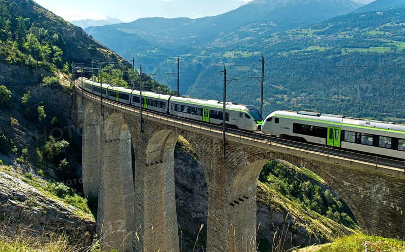 Two coupled RABe 528 multiple units of the BLS AG railway company cross the Luogelkin Viaduct on the Lötschberg south ramp section near Hohtenn, Valais, Switzerland
