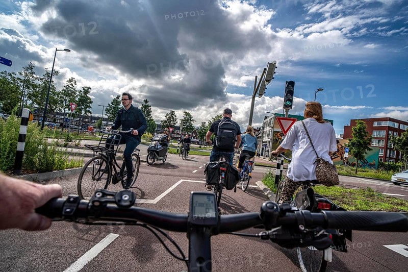 Cycling in the Dutch city of Utrecht, cycle path separated from the carriageway for cars, heavy traffic, Netherlands
