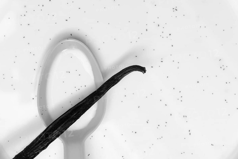 Spoon with vanilla pod, vanilla seeds in milk