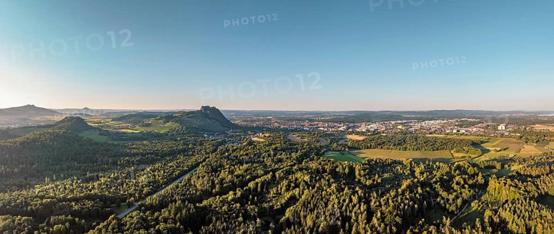 Luftbild, Panorama von einer vulkanisch geprägten Landschaft im Abendlicht, mit dem Hohenstoffeln, Hohenhewen und Hohentwiel von links gesehen, rechts am Horizont die Stadt Singen, und der angrenzenden Gemeinde Rielasingen-Worblingen, Hegau, Landkreis Konstanz, Baden-Württemberg, Deutschland