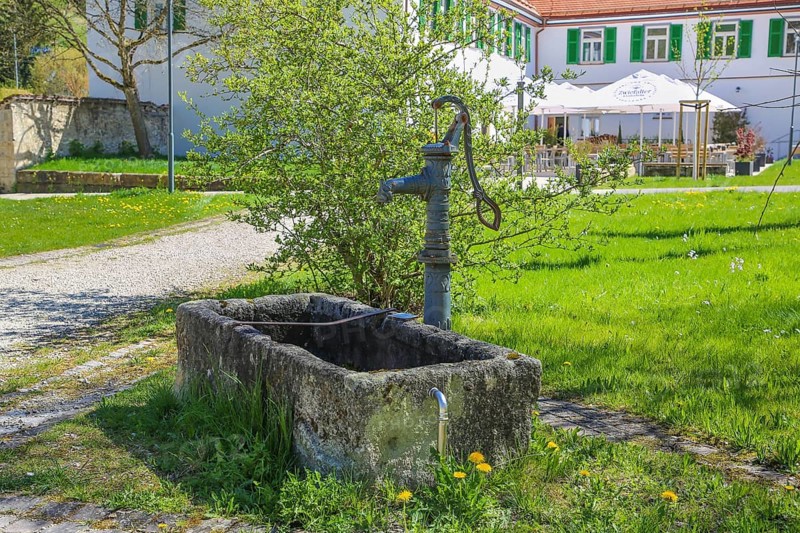 Fountain, stone basin with hand pump, water dispenser, behind Gestütsgasthof, near the Lauterquelle, municipality of Gomadingen, Swabian Alb, Baden-Württemberg, Germany