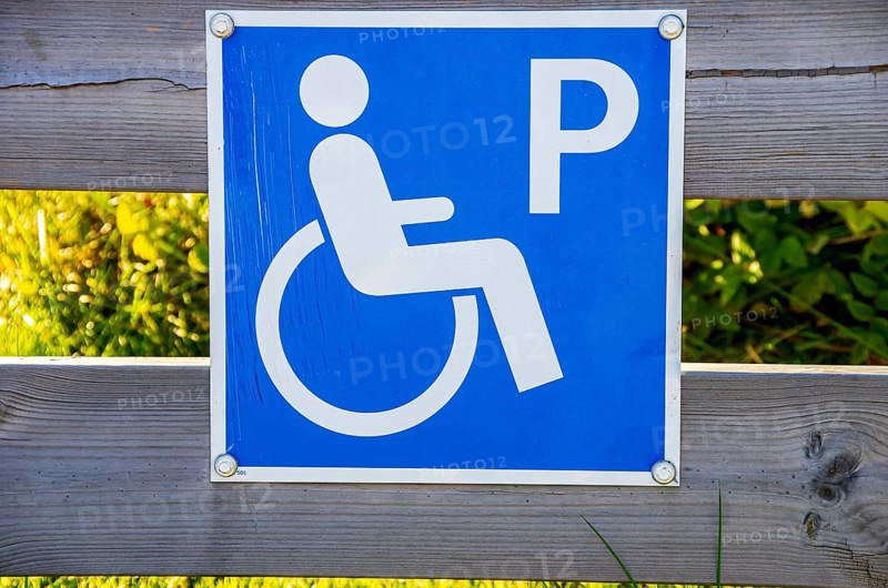 Sign with pictogram Car park for the disabled on a wooden fence, near Henan on Orust, Bohuslän, Västra Götalands län, Sweden