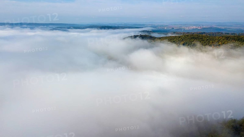 Bird's eye view of aerial view of high fog lying over valleys of low mountain ranges, Germany