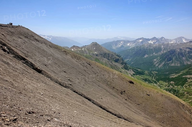 View of slope in high Alps with gravel scree on ring road Road loop around mountain peak Cime de la Bonette hilltop above tree line next to Alpine pass Col de la Bonette, Jausiers, Provence-Alpes-Cote d'Azur, Hautes-Alpes, Alpes-de-Haute-Provence, France