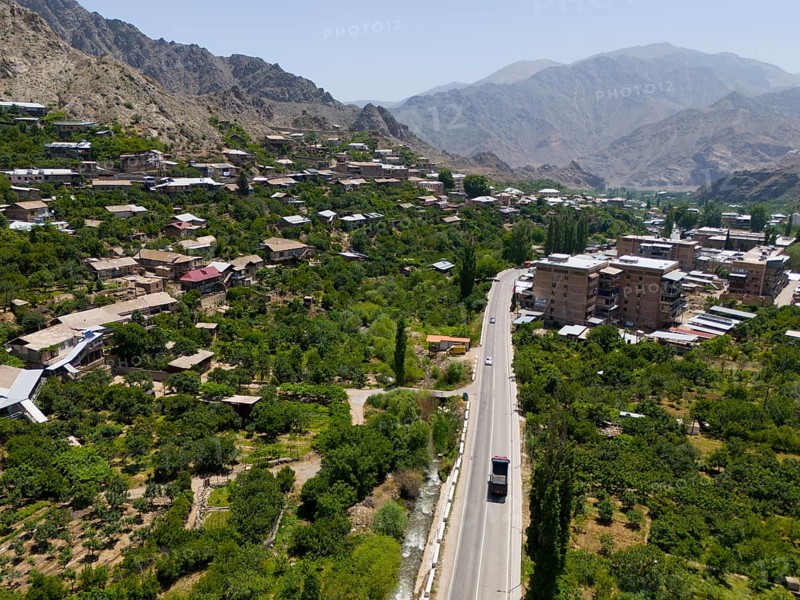 Village with a road winding through a mountainous landscape with green vegetation, aerial view, Meghri, Syunik province, mountains in the background are located in Iran, Armenia, Asia