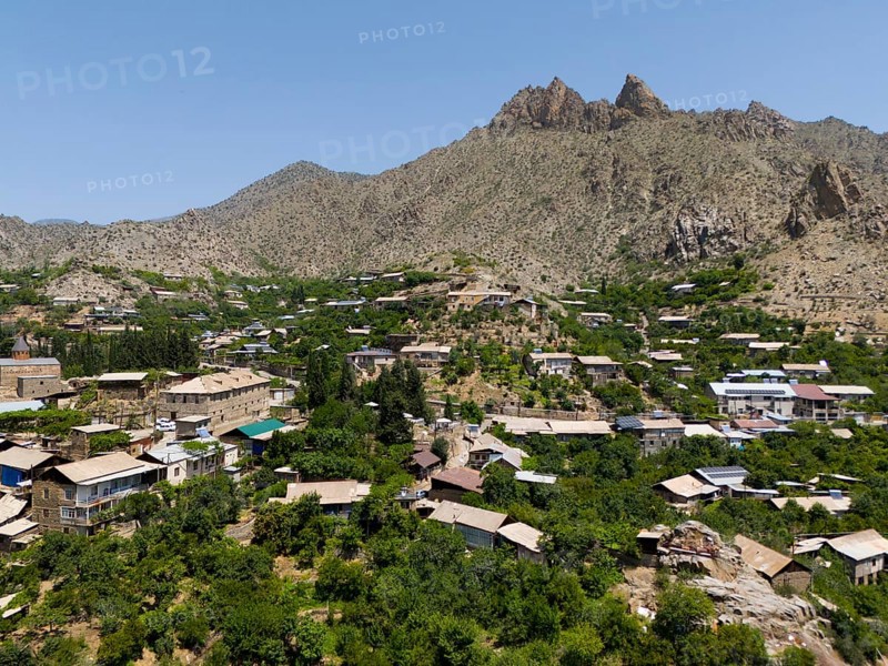 Village surrounded by lush vegetation and high mountains in a sunny landscape, aerial view, Meghri, Syunik province, not far from the border with Iran, Armenia, Asia