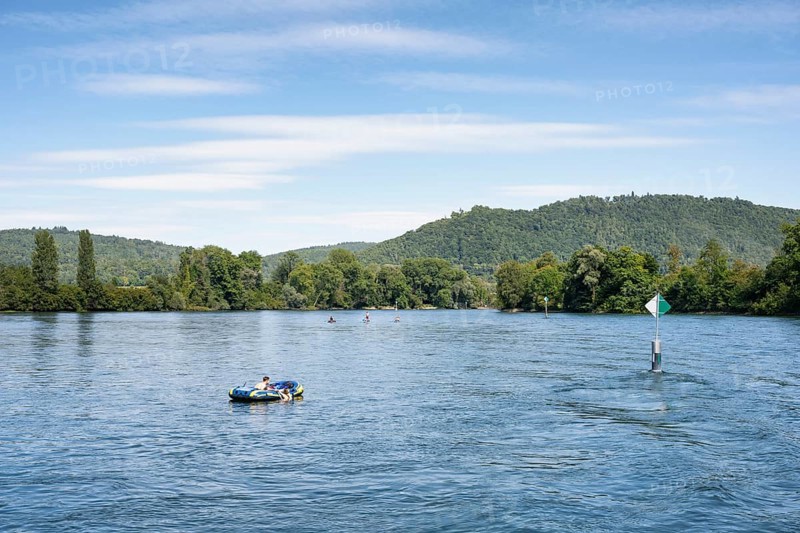 Inflatable boat, stand up paddler, swimming next to a fairway on the Rhine, Hochrhein near Hemishofen, Stein am Rhein, Canton Schaffhausen, Switzerland