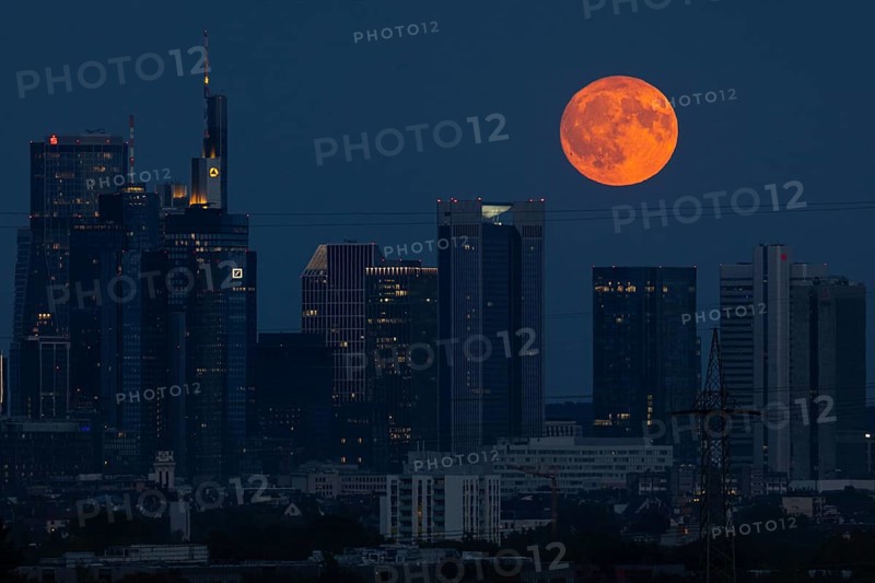 The full moon passes over the Frankfurt banking skyline, Frankfurt am Main, Hesse, Germany