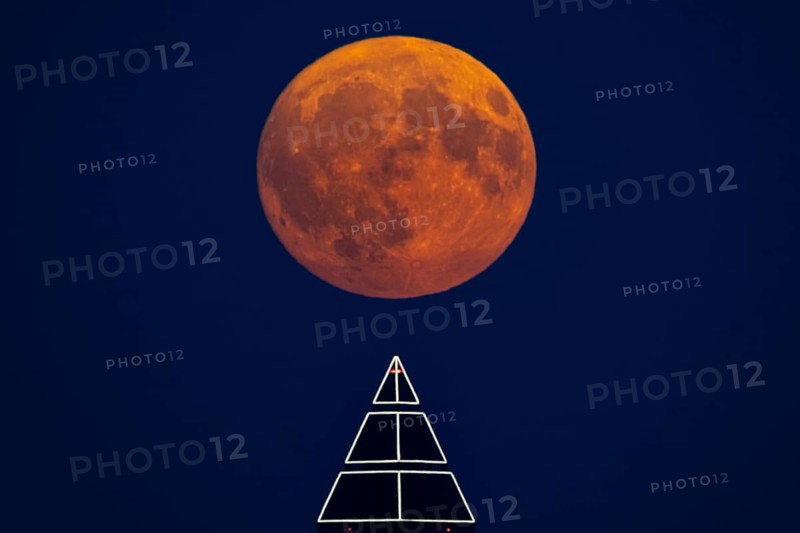 The full moon passes over the top of the Messeturm in Frankfurt am Main, Frankfurt am Main, Hesse, Germany
