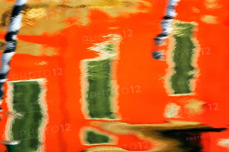 Colourful façade detail reflected in the water of a canal, Burano, Venice, Veneto, Italy