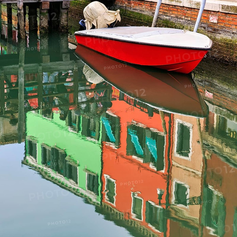 Colourful façade details reflected in the water of a canal, motorboat, Burano, Venice, Veneto, Italy