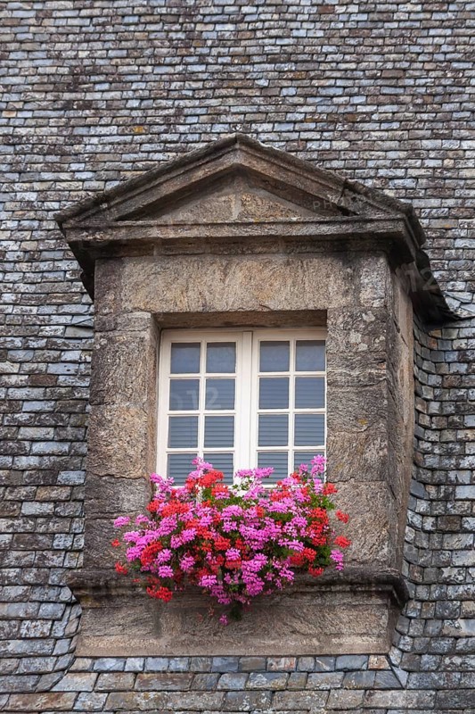 Dormer window with glazing bars in a historic house, floral decoration, old town of Guingamp, Département Côtes-d'Armor, Brittany, France