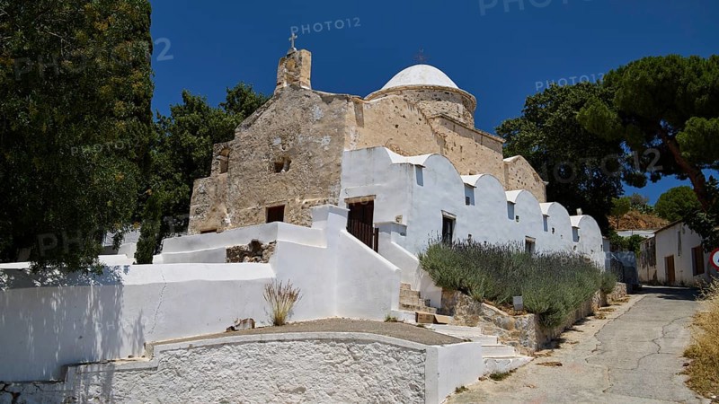 Whitewashed, stone church with dome and trees under a clear blue sky, basilica, church, Agios Theologos, Leros, Dodecanese, Greek Islands, Greece