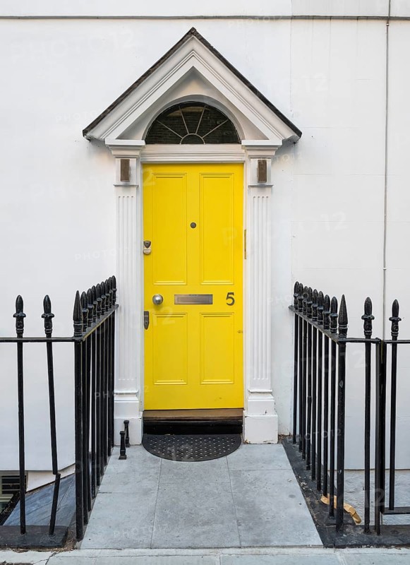 Bright yellow front door with house number five and neoclassical triangular gable, Palladian-style entrance, white façade, black fence, Kensington, London, England, United Kingdom