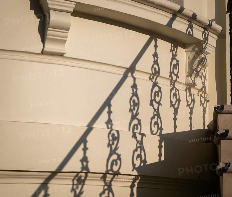 Shadow of an artistically decorated banister on a house wall, Notting Hill, London, England, Great Britain