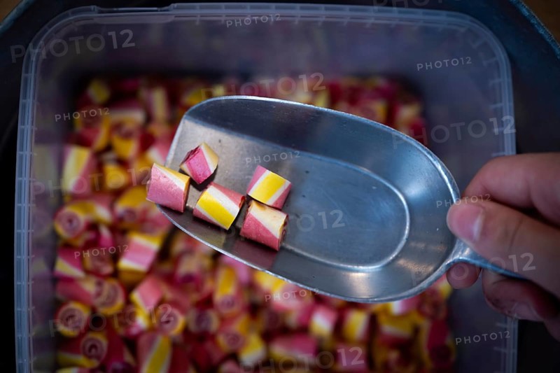 Colourful sweets are taken out of a container with a ladle, Ringkøbing, Ringkøbing Fjord, Denmark