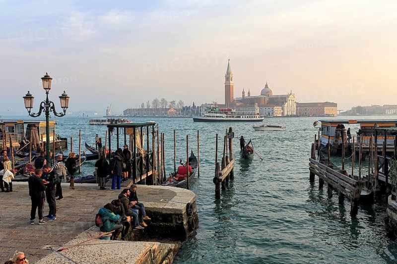 Boat dock at St Mark's Square, San Giorgio Maggiore church in the background, evening sky, Venice, Italy