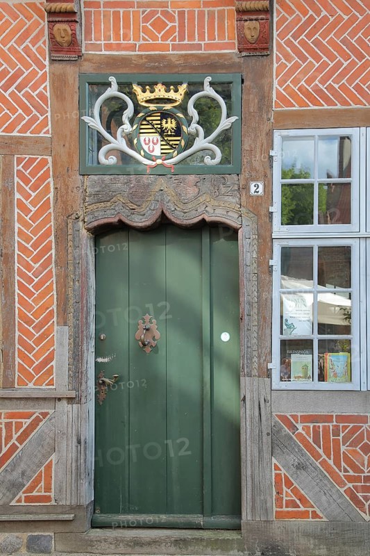Door with coat of arms and golden crown at the entrance to the Eulenspiegel Museum, half-timbered house, Am Markt, Mölln, Schleswig-Holstein, Germany