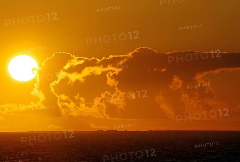 Intense sunset over the sea with dramatic clouds and colours, crossing between Orkney and Shetland Islands, Scotland, Great Britain