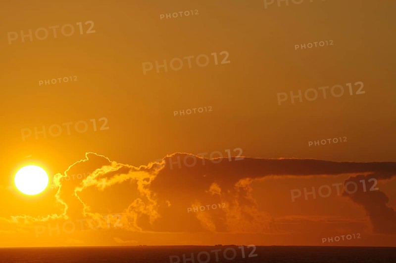 Sunset over the sea with intense orange clouds, crossing between Orkney and Shetland Islands, Scotland, Great Britain