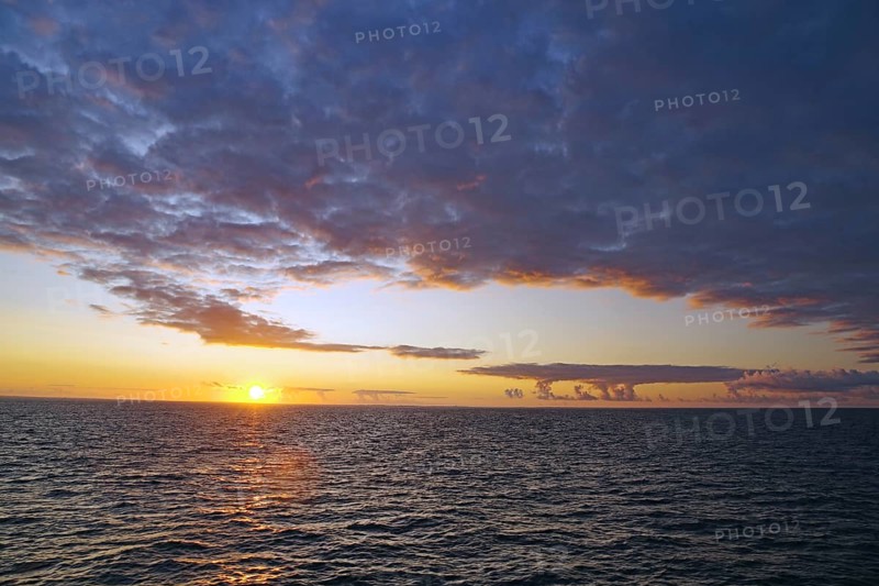 View of the sea at sunset with clouds and colourful sky, crossing between Orkney and Shetland Islands, Scotland, Great Britain