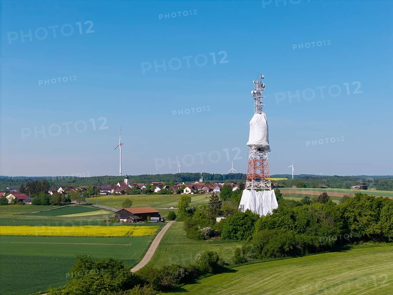 Landscape with transmission tower and many wind turbines surrounded by fields, radio tower being renovated, near Hohenstadt, Swabian Alb, Baden-Württemberg, Germany