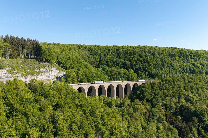A viaduct leads over a dense forest landscape under a blue sky, Drachenloch bridge on the Drackenstein slope, near Drackenstein, Swabian Alb, Baden-Württemberg, Germany