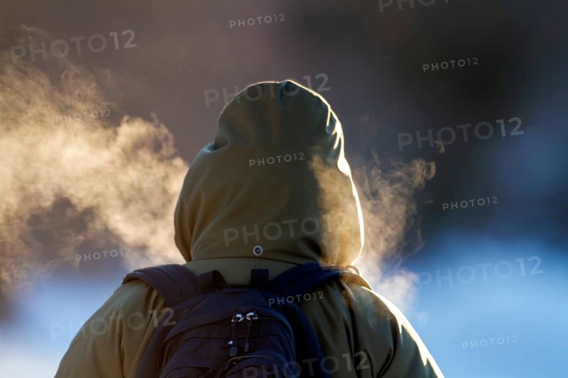 Person walking in very cold weather, Visual effect of the steam seen when exhaling in cold weather. City of Montreal, Province of Quebec, Canada, North America