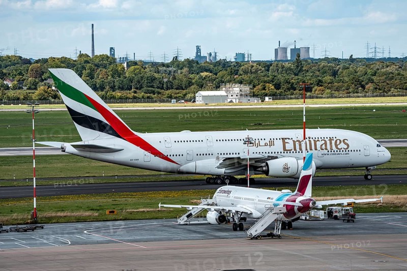 Düsseldorf Airport, Eurowings Airbus aircraft on the apron, Emirates Airbus A380-800 on its way to take-off, in the background the HKM steelworks in Duisburg, North Rhine-Westphalia, Germany