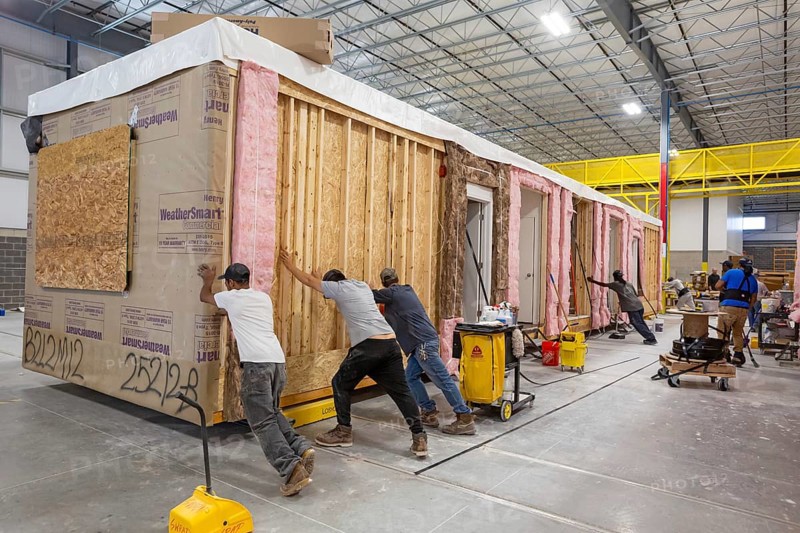Romulus, Michigan - Workers build apartments in Ginosko Modular 's factory using modular construction methods. They are moving one module to the next assembly station. The units will be assembled into an apartment building in Detroit for low to moderate income households