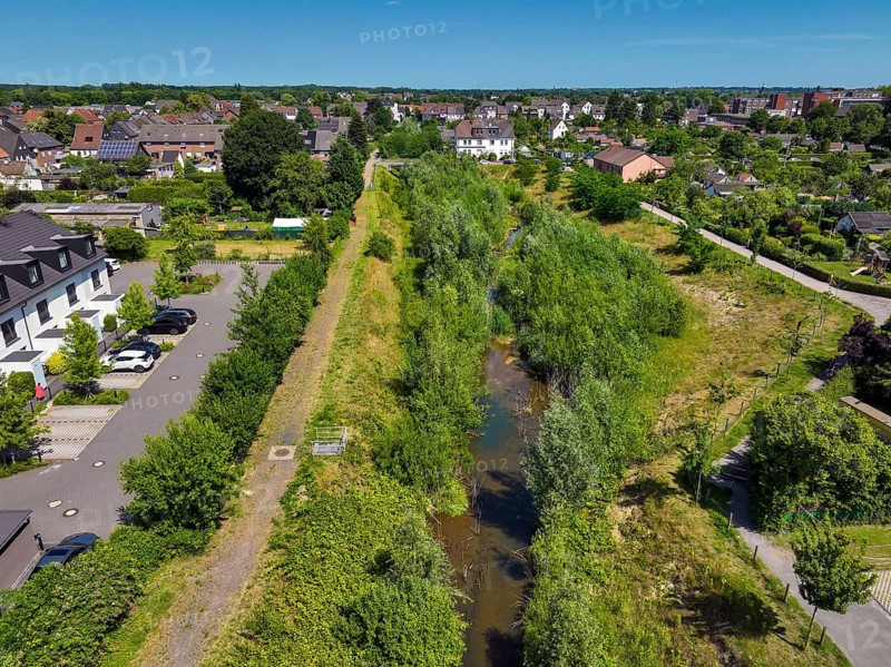 Recklinghausen, North Rhine-Westphalia, Germany - Renaturalised Hellbach, renaturalised watercourse, the Hellbach is now free of wastewater after the construction of a parallel sewer, is part of the Emscher river system and thus part of the Emscher conversion, was previously an open, above-ground wastewater channel, mixed water channel with surface water and wastewater. The renaturalised Hellbach stream strengthens the city's climate resilience, promotes biodiversity and helps to mitigate urban warming caused by climate change
